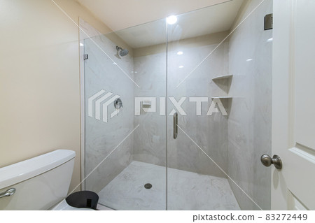 Interior of a bathroom with frameless shower stall 83272449