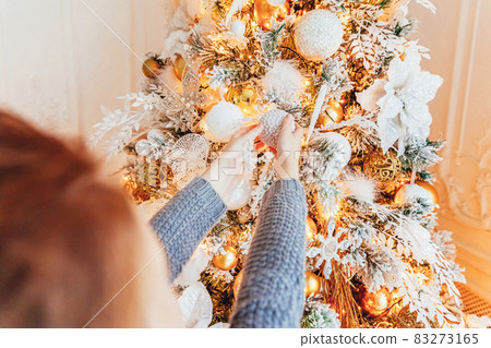 Little girl decorating Christmas tree on Christmas eve at home. Young kid in light bedroom with winter decoration. Happy family at home. Christmas New Year december time for celebration concept. Little girl decorating Christmas tree on Christmas eve at home. Young kid in light bedroom with winter decoration. Happy family at home. Christmas New Year december time for celebration concept. 83273165
