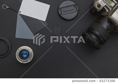 Photographer workplace with dslr camera system, camera cleaning kit, lens and camera accessory on dark black table background. Hobby travel photography concept Flat lay top view copy space Photographer workplace with dslr camera system, camera cleaning kit, lens and camera accessory on dark black table background. Hobby travel photography concept Flat lay top view copy space 83273166