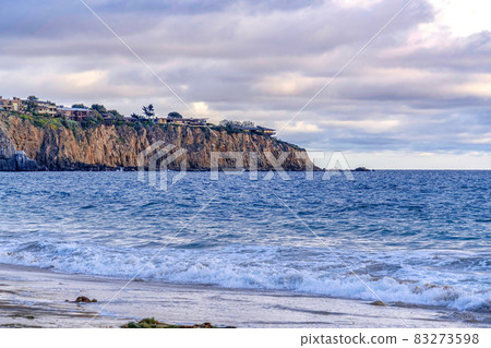 Ocean and mountain with houses in Laguna Beach California against cloudy sky Ocean and mountain with houses in Laguna Beach California against cloudy sky 83273598