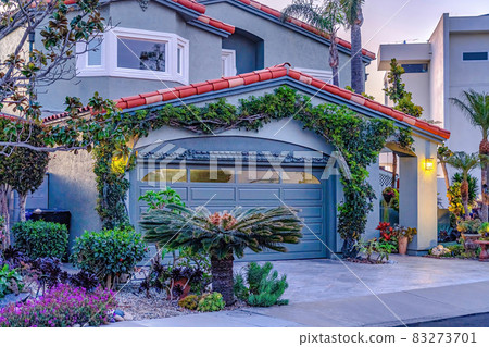 facade of gray house with bay window gable roof over garage and arched entrance 83273701