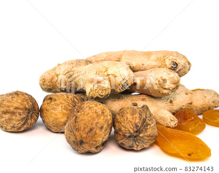 Ginger root with walnuts and dried apricots apricots on a white background. 83274143