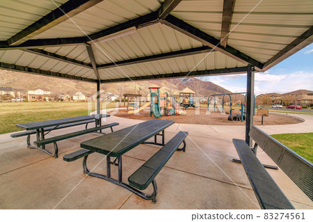 Fun park with pavilion childrens playground and grass land against mountain view 83274561