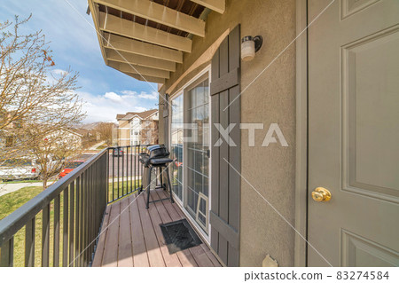 Barbecue grill on small balcony with roof overhang and huge window with shutters Barbecue grill on small balcony with roof overhang and huge window with shutters 83274584