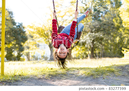 A girl playing with a swing 83277399