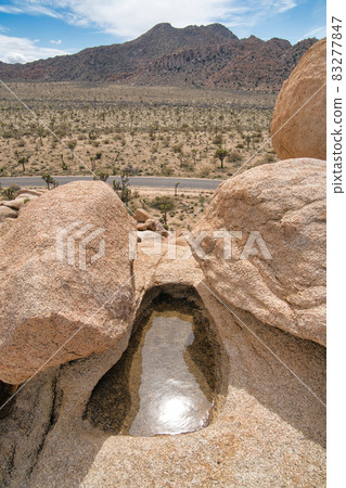 Puddle of water on holes from erosion of rocks at Joshua Tree National Park Puddle of water on holes from erosion of rocks at Joshua Tree National Park 83277847