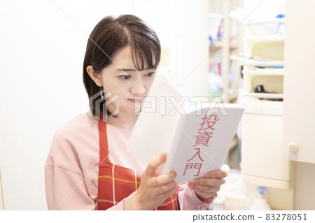 A woman reading an investment book seriously in the washroom 83278051