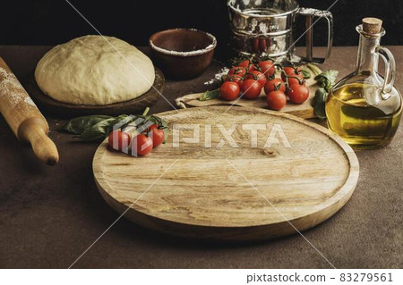 high angle of pizza dough with wooden board and tomatoes. High quality and resolution beautiful photo concept high angle of pizza dough with wooden board and tomatoes. High quality and resolution beautiful photo concept 83279561