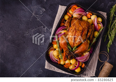 Whole baked chicken with vegetables. 83280825