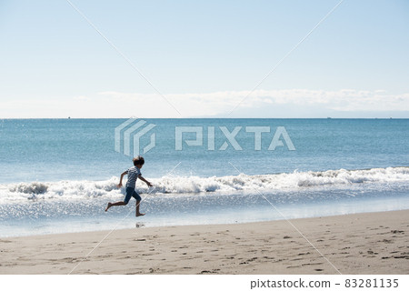 A boy running barefoot on the beach on a sandy beach 83281135