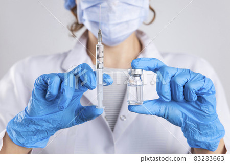 Doctor holding syringe, medical injection in hand with glove Doctor holding syringe, medical injection in hand with glove 83283663