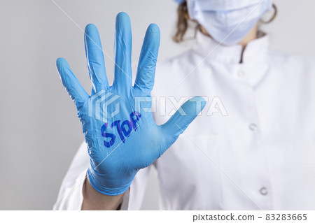 Stop written on the doctor's hand with surgical glove 83283665