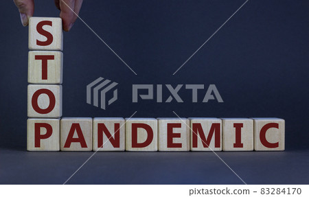Wooden cubes with the expression 'stop pandemic'. Beautiful grey background, male hand. Medical and covid-19 pandemic concept, copy space. 83284170
