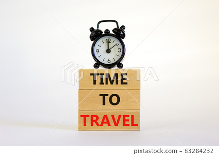 Time to travel symbol. Wooden blocks with concept words 'Time to travel'. Black alarm clock. Beautiful white background. Business and time to travel concept. Copy space. Time to travel symbol. Wooden blocks with concept words 'Time to travel'. Black alarm clock. Beautiful white background. Business and time to travel concept. Copy space. 83284232