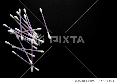 a lot of cotton buds on black background a lot of cotton buds on black background 83284394