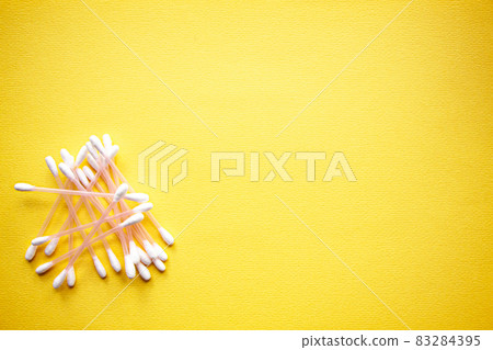 a lot of cotton buds on yellow background a lot of cotton buds on yellow background 83284395