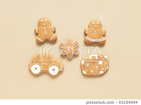 Happy New Year composition, gingerbread man and woman, suitcase and car on beige background. Happy New Year composition, gingerbread man and woman, suitcase and car on beige background. 83284994