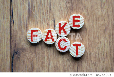 Business and design concept - surreal abstract geometric wooden circles with words 'FACT FAKE' concept on wood floor. 83285003
