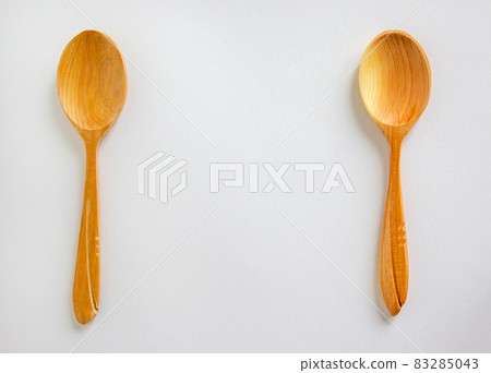 Two beautiful wooden spoons isolated on white background. Two beautiful wooden spoons isolated on white background. 83285043