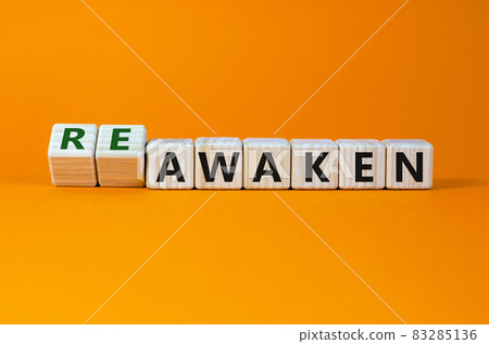 Reawaken symbol. Turned cubes and changed the word 'awaken' to 'reawaken'. Beautiful orange background, copy space. Business and reawaken or awaken concept. 83285136