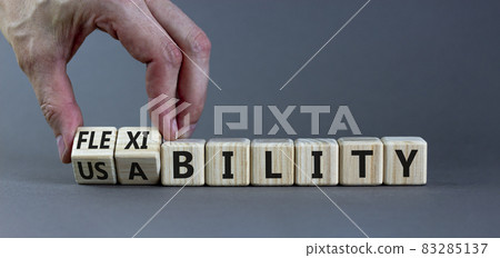 Flexibility and usability symbol. Businessman turns wooden cubes and changes words 'usability' to 'flexibility'. Beautiful grey background, copy space. Business, flexibility and usability concept. 83285137
