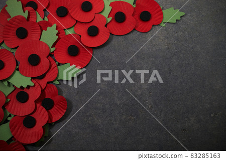 World War remembrance day. Red poppy is symbol of remembrance to those fallen in war. Red paper poppies on dark stone background 83285163