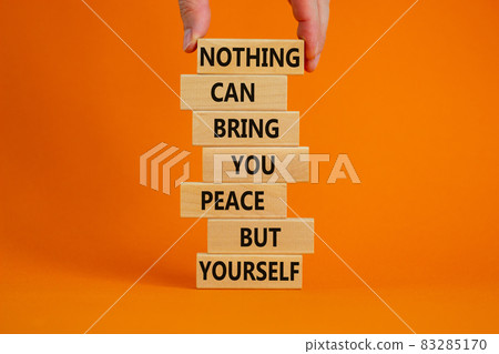 Concept of building success foundation. Businessman hand. Wooden blocks with words nothing can bring you peace but yourself. Beautiful orange background, copy space. Business and motivational concept. 83285170