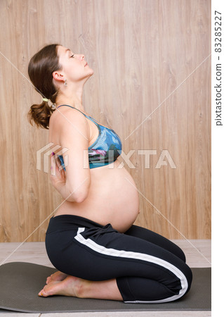 Pregnant woman doing yoga exercise meditating Pregnant woman doing yoga exercise meditating 83285227