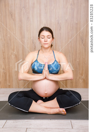 Pregnant woman doing yoga exercise meditating Pregnant woman doing yoga exercise meditating 83285228