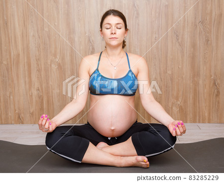 Pregnant woman doing yoga exercise meditating Pregnant woman doing yoga exercise meditating 83285229