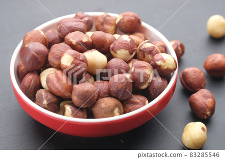 hazelnuts in a container on black background, hazelnuts in a container on black background, 83285546