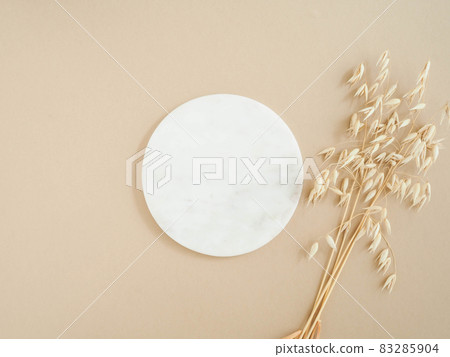 Marble white round podium and bouquet of dry oats on beige background. 83285904