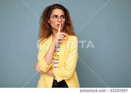 Photo of young beautiful brunette curly woman with sincere emotions wearing casual yellow jacket and 83285907