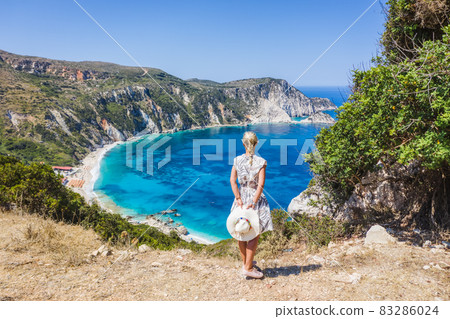 A tourist woman enjoying beautiful Petani beach on Kefalonia Ionian island, Greece, during her summer vacation holiday A tourist woman enjoying beautiful Petani beach on Kefalonia Ionian island, Greece, during her summer vacation holiday 83286024