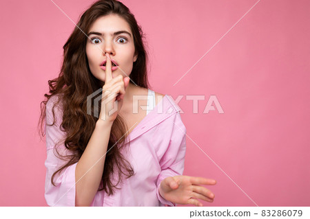 Photo of young shocked beautiful wavy-haired brunette woman with sincere emotions wearing casual Photo of young shocked beautiful wavy-haired brunette woman with sincere emotions wearing casual 83286079