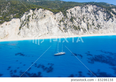 Lefkada, Greece. Remote white Egremni beach with lonely luxury yacht boat on the turquoise colored bay on Ionian Sea Lefkada, Greece. Remote white Egremni beach with lonely luxury yacht boat on the turquoise colored bay on Ionian Sea 83286138