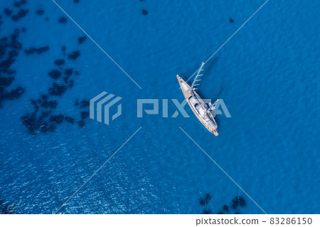 Lefkada, Greece. Remote white Egremni beach with lonely luxury yacht boat on the turquoise colored bay on Ionian Sea Lefkada, Greece. Remote white Egremni beach with lonely luxury yacht boat on the turquoise colored bay on Ionian Sea 83286150