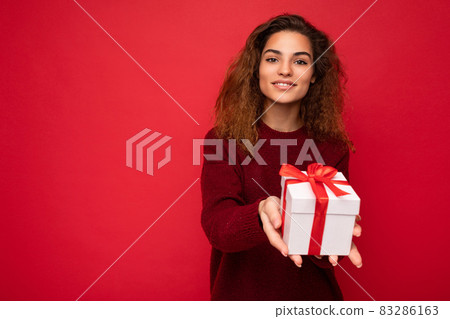 Beautiful happy young brunette woman isolated over colourful background wall wearing stylish casual 83286163