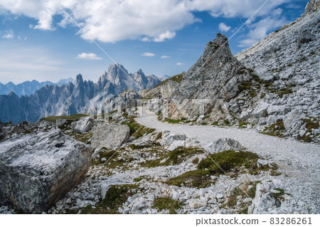 Hiking trail to Cime di Lavaredo with Cadini di Misurina mountain group in background. Dolomites, Italy 83286261