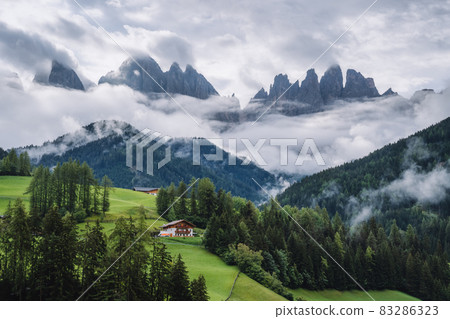 St Magdalena church in Val di Funes valley, Dolomites, Italy. Furchetta and Sass Rigais mountain peaks in background St Magdalena church in Val di Funes valley, Dolomites, Italy. Furchetta and Sass Rigais mountain peaks in background 83286323