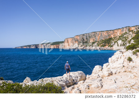 Aerial drone view of man enjoying rocky coastline close to Alaties Beach, Kefalonia, Ionian islands, Greece 83286372