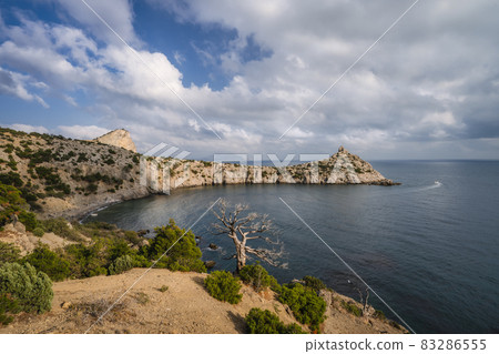 Panorama of cape Kapchik near coastline of Black Sea. Shape of mountain reminds sleeping animal, face turned to left, rock on top is like ear, small island similar to paw. Shot in Novyi Svit, Crimea 83286555