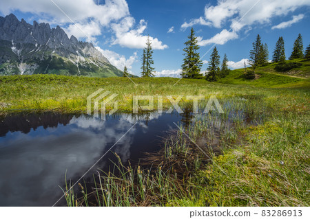 Mountain pond with Wilder Kaiser range reflecting in water pond, Tirol - Austria Mountain pond with Wilder Kaiser range reflecting in water pond, Tirol - Austria 83286913