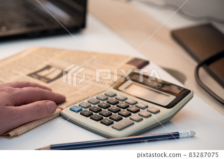Calculator and finance newspaper. Coronavirus concept. Work from home concept Calculator and finance newspaper. Coronavirus concept. Work from home concept 83287075