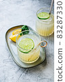 Citrus cocktail with lemon juice and lime in a glass on the table. 83287330