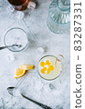 Citrus cocktail with lemon juice and decorated with lemon peel on the table. 83287331