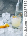 Citrus cocktail with lemon juice and decorated with lemon peel on the table. 83287332
