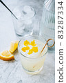 Citrus cocktail with lemon juice and decorated with lemon peel on the table. 83287334