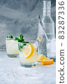 Ice lemonade in glass with lemon pieces, fresh mint and ice cubes. 83287336
