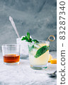 Ice lemonade in glass with lemon pieces, fresh mint and ice cubes. 83287340
